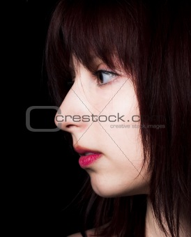 Beautiful girl gazing into the darkness with lot of copy space