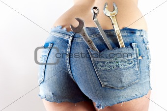 Lower body of a girl with wrench and spanner in her pockets