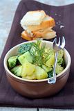 potato salad with cucumber and dill on a brown background