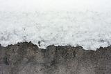 Snow over concrete wall