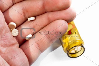Hand of a man holding pills with medicine on background