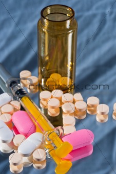 Medicine bottle and sirynge and pills and reflection