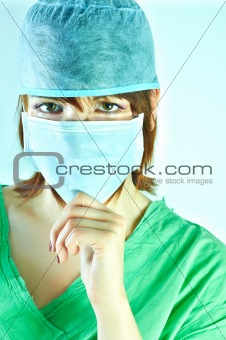 Woman surgeon holding her chin and has a serious look on her face