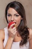 Beautiful young woman eating an apple