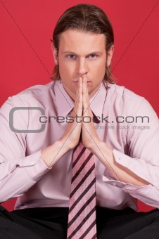 Thoughtful businessman with hand clasped