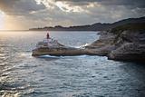 Lighthouse on rocks over the sea