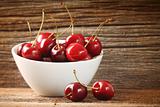 Red cherries in bowl on barn wood