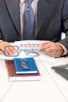 Businessman sitting at office desk and working  with  documents. Close-up. 
