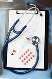 Note pad and blister strip with pills and blue stethoscope