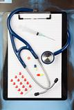 Note pad and blister strip with medicine and blue stethoscope