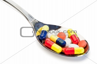 Spoon full of different kind of pills