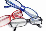 Three pairs of spectacles with blue red and black frames