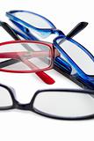 Three pairs of glasses with blue black and red frames