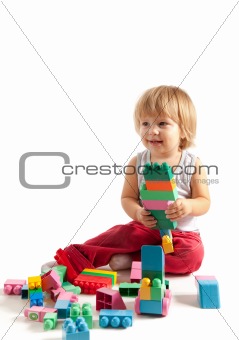 Smiling little boy playing with blocks 