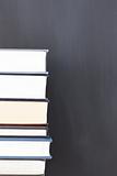 Stack of books and a clean blackboard