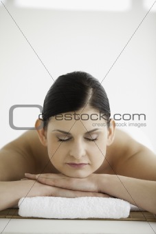 Dark-haired woman getting a spa treatment while closing her eyes