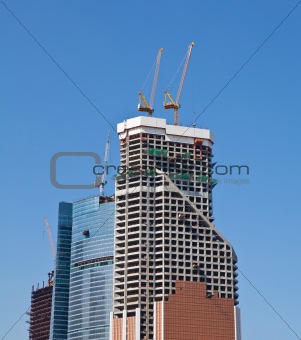 Construction cranes on the construction of office building