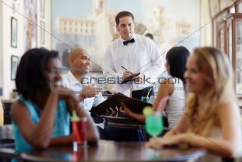 people ordering meal to waiter in restaurant