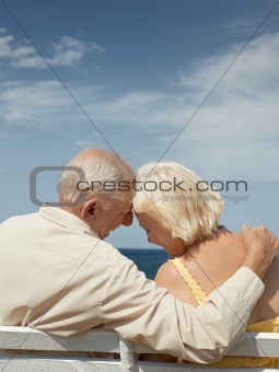 old man and woman on bench at the sea