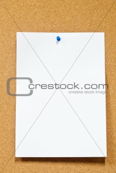 white note paper with thumbtack on corkboard