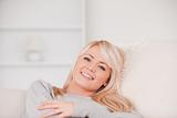 Smiling blonde woman lying on a sofa