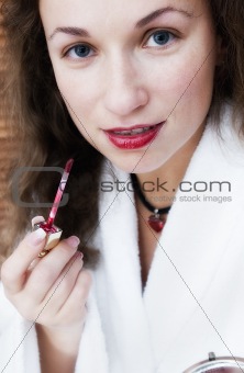 Woman  applying lipstick on lips
