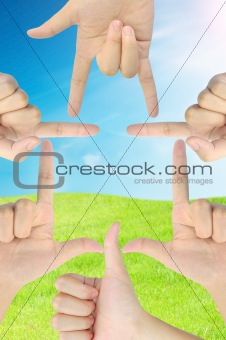hand as home shape on fresh grass and blue sky