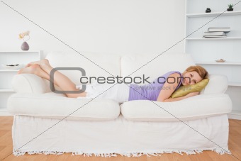 Beautiful woman posing and smiling while lying on a sofa
