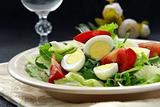 salad with quail eggs and arugula on beige plate  black background