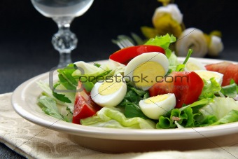 salad with quail eggs and arugula on beige plate  black background