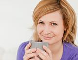 Portrait of a good looking red-haired woman holding a cup of cof