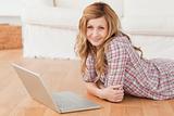 Young woman looking at the camera while chatting on her laptop
