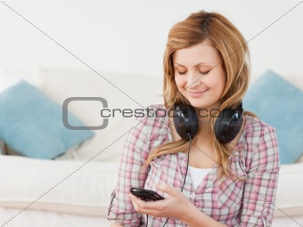 Smiling blond-haired woman with headphones and mp3 player