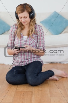 Relaxed blond-haired woman listening to music with headphones