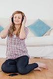 Attractive blond-haired woman listening to music with headphones