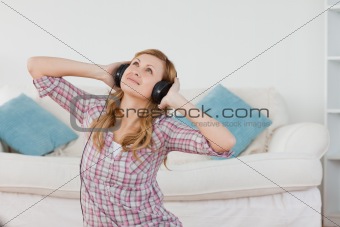 Cute blond-haired woman listening to music with headphones