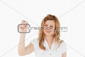 Blonde woman drawing a scheme looking towards the camera