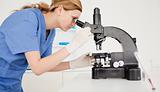 Female scientist looking through a microscope
