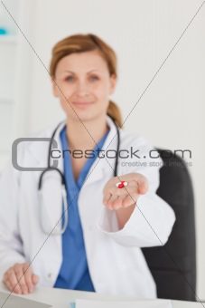 Blond-haired doctor showing pills to the camera
