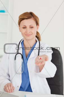 Cute female doctor showing pills to the camera
