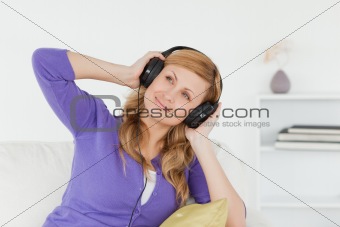 Attractive red-haired woman listening to music and enjoying the 