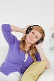 Portrait of a beautiful red-haired woman listening to music and 