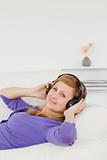 Smiling red-haired woman listening to music and enjoying the mom