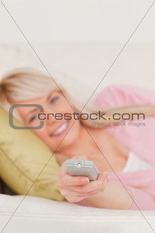 Beautiful blonde woman posing while lying on a sofa