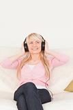 Beautiful woman listening to music on her headphones while sitti