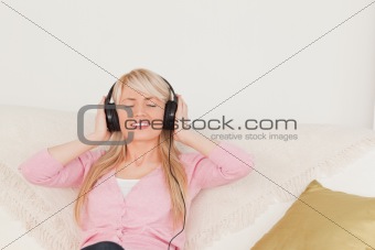 Good looking woman listening to music on her headphones while si