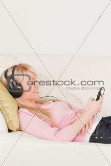 Good looking woman listening to music on her headphones while ly