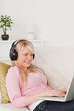 Beautiful blonde woman listening to music on her headphones whil