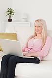 Young beautiful woman relaxing with a laptop while sitting on a 