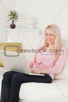 Young beautiful woman relaxing with a laptop while sitting on a 